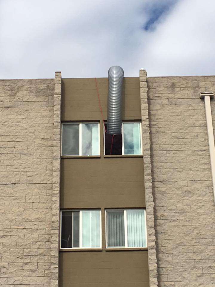 Mylar Duct routed vertically through a multi-story building window.
