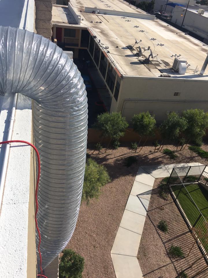 Mylar Duct dropping from a rooftop into a lower commercial area.